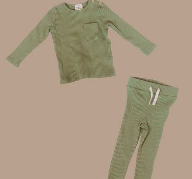 Flat lay image of organic cotton rib two piece set in neutral basil color. Set includes a long sleeve top with Magnetic Buttons at the neck in sizes through 12-18 months as well as leggings with a faux drawstring.