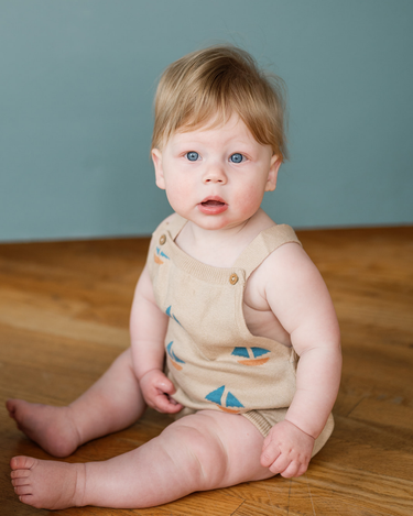 Baby wearing romper with sail boat print