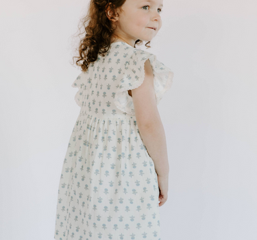 Little girl wearing cotton muslin flutter sleeve dress in cheerful floral 