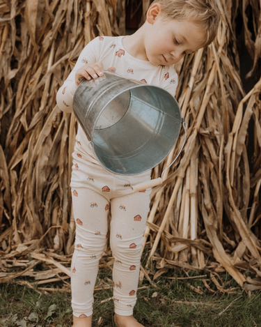 child wearing modal pajama set in light beige color with farm print