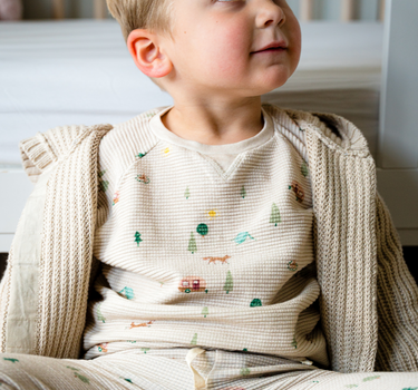 Image shows baby boy wearing organic cotton waffle long sleeve tee in camping. 