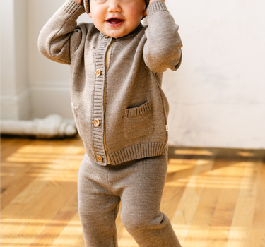 image shows baby boy wearing merino wool baby cardigan in heather brown