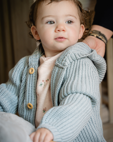 Image shows baby girl wearing pima cotton knit hoody in pearl blue. 