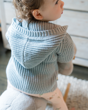 Image shows baby girl wearing pima cotton knit hoody in pearl blue. 