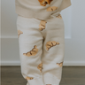 Baby wearing organic cotton knit croissant patterned joggers.