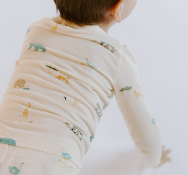 Image shows toddler boy wearing modal pajama set in zoo print.