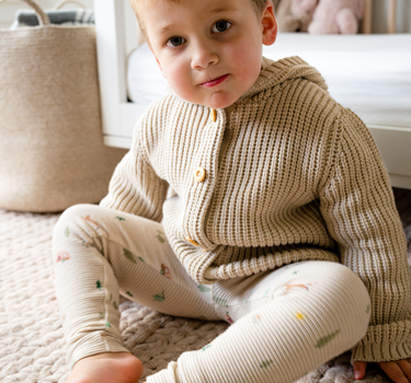 Image shows toddler boy wearing pima cotton knit waffle hoody in oatmeal. 