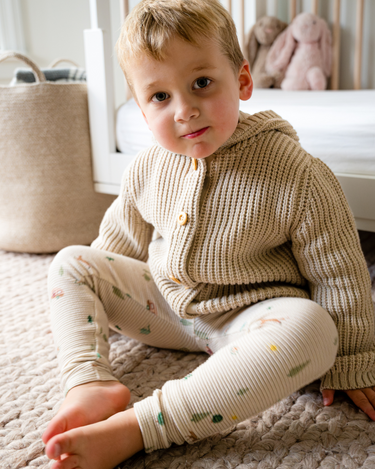 Image shows toddler boy wearing pima cotton knit waffle hoody in oatmeal. 