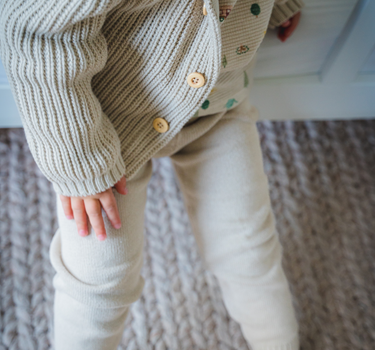 Image shows toddler boy wearing pima cotton knit waffle hoody in oatmeal. 