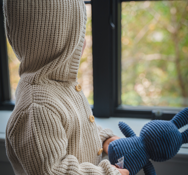 Image shows toddler boy wearing pima cotton knit waffle hoody in oatmeal. 